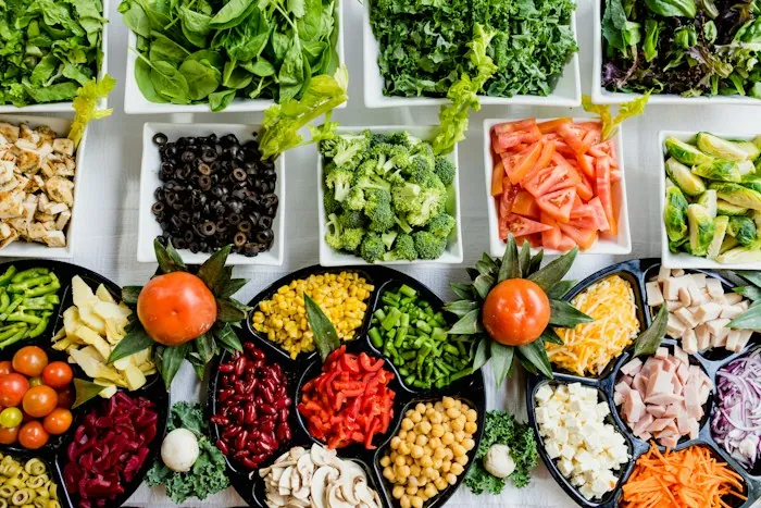 Overhead view of bowls filled with beans, chickpeas, vegetables and grains