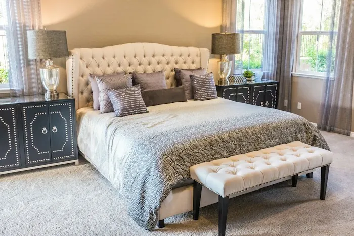 A tidy bedroom with a large bed, soft bedding and bedside lamps