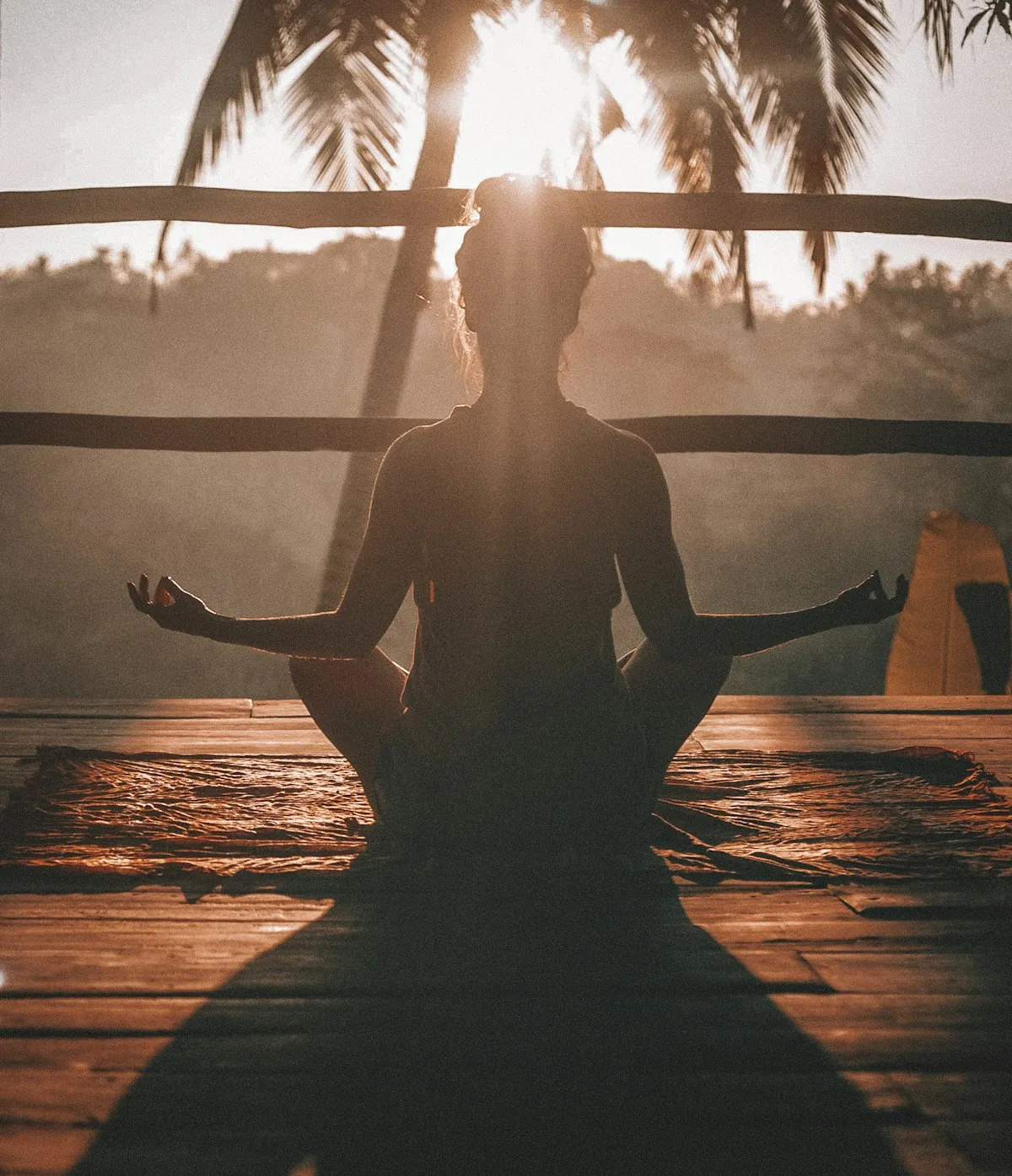 A person sitting cross-legged in meditation in warm evening light