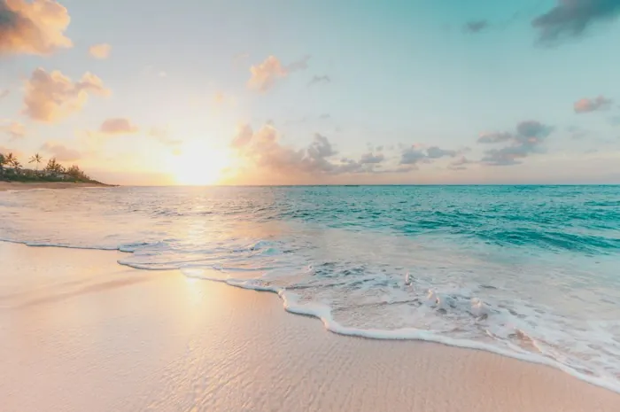 Sunrise over a calm beach with gentle waves