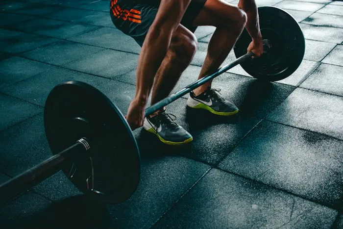 An athlete gripping a loaded barbell before a deadlift