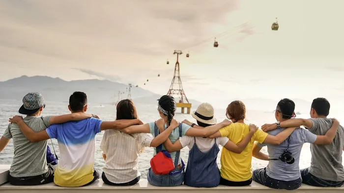 A group of friends with arms around each other sharing meaningful connection outdoors