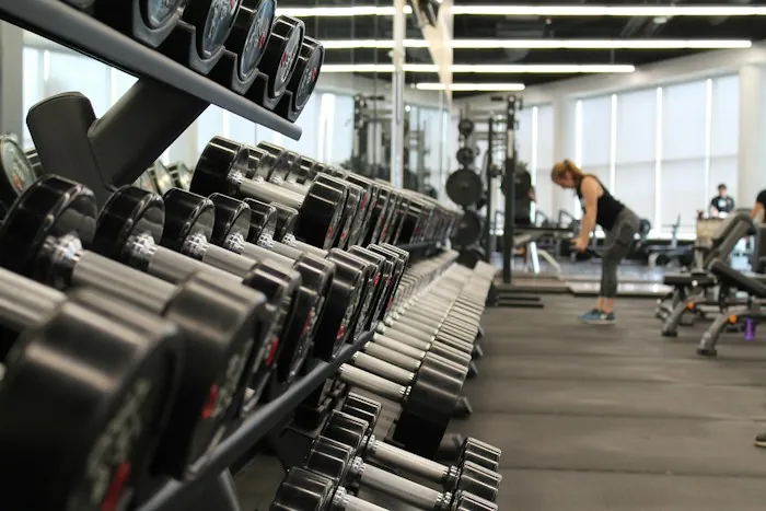 Rows of dumbbells on racks in a bright gym
