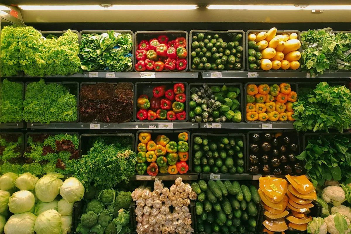 A grocery store produce section stocked with rows of fresh vegetables