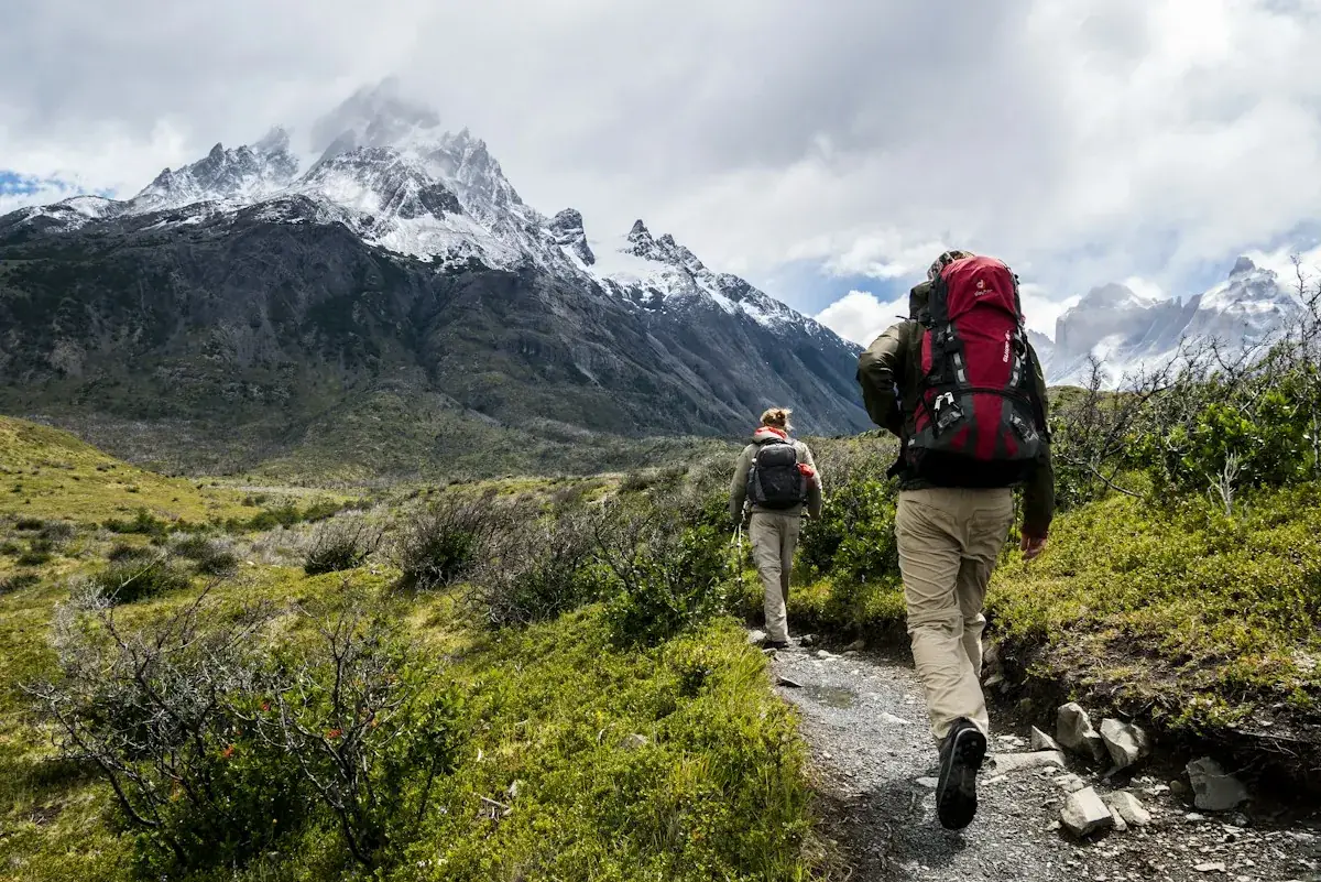 Two hikers walking a mountain trail together, a small everyday step toward healthier living