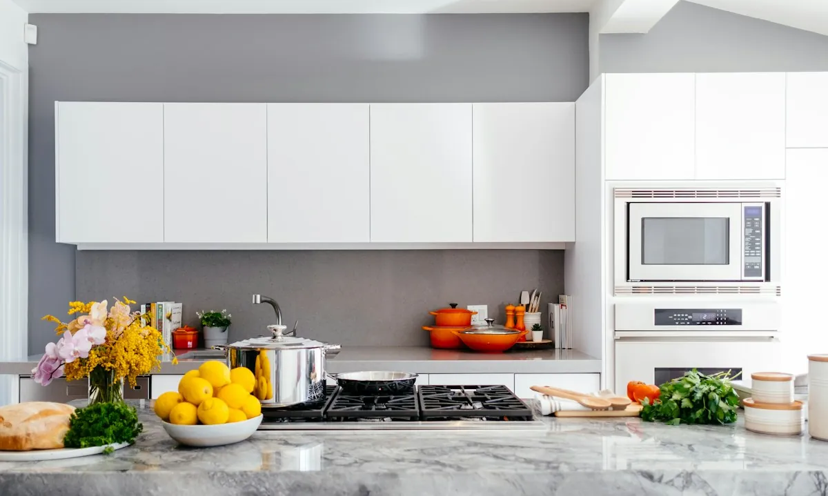 A bright kitchen with a bowl of lemons and fresh herbs on the counter