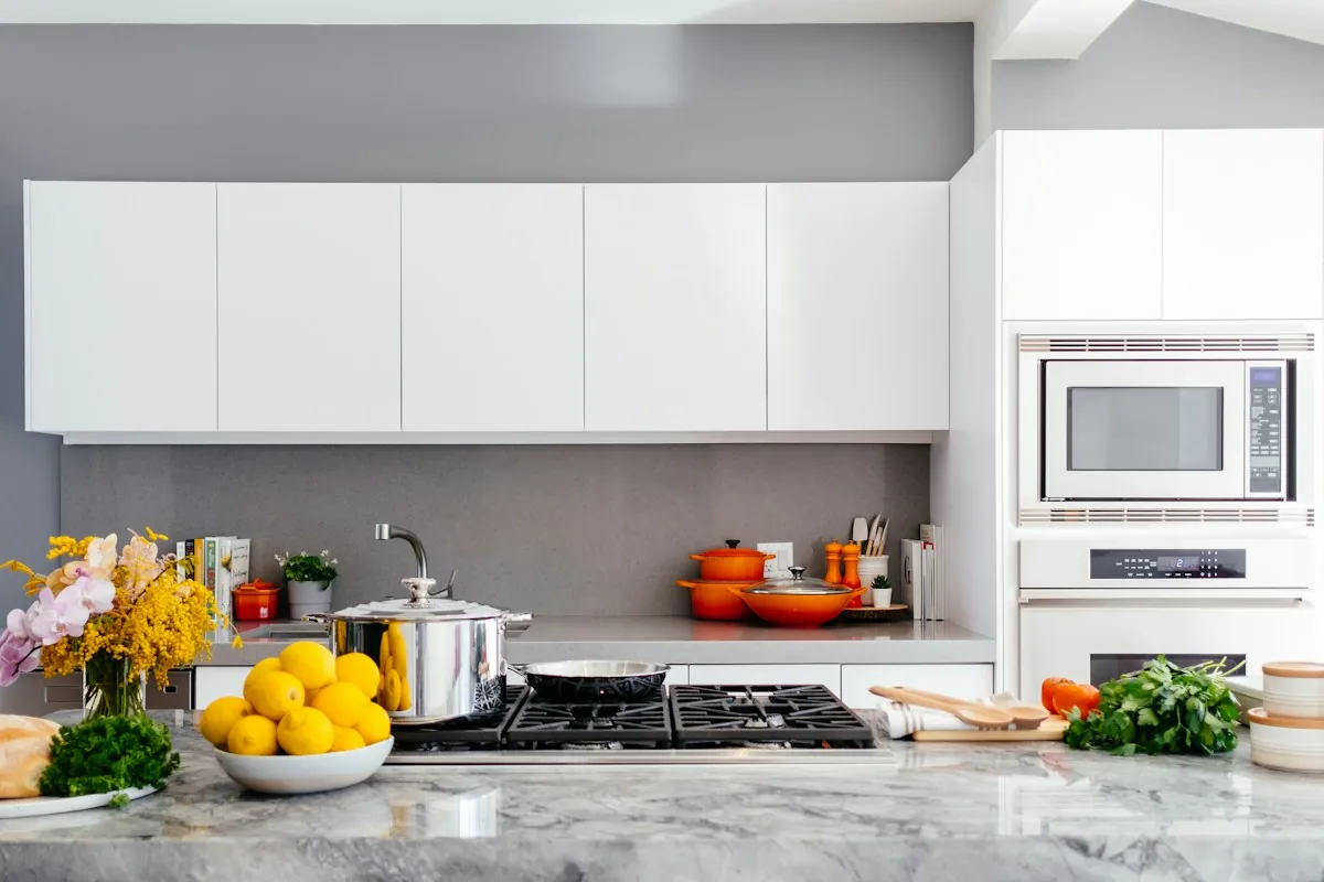 A bright kitchen with a bowl of lemons and fresh herbs on the counter