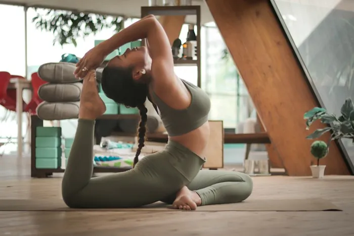 A woman in a deep stretching pose in a bright living space