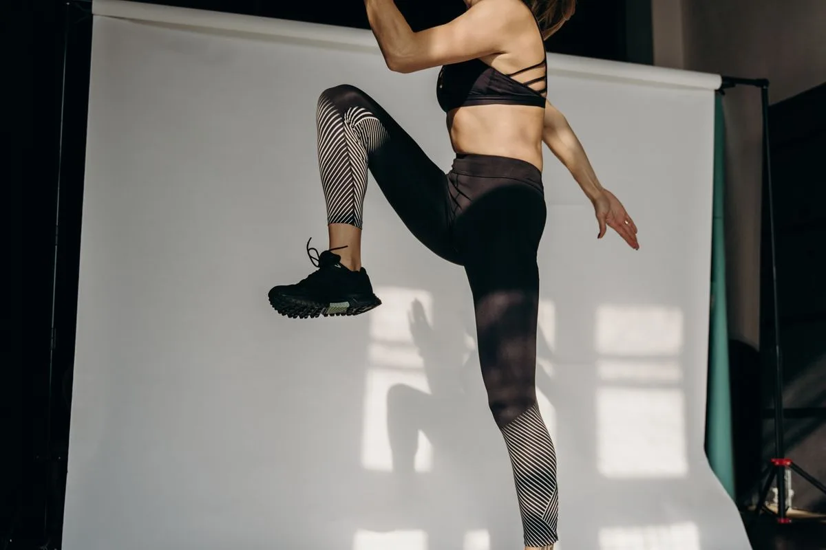 A woman jumping energetically during an indoor workout