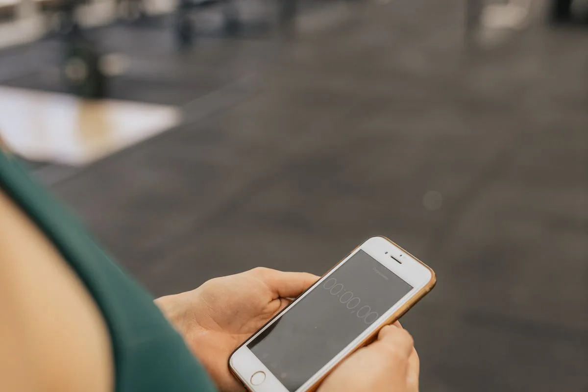 A close view of hands starting a workout timer on a phone