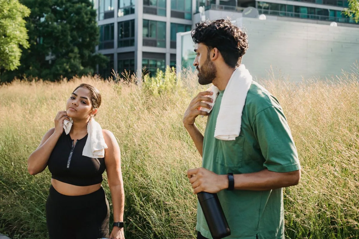 Two people wiping down with towels as they cool down after exercise outdoors