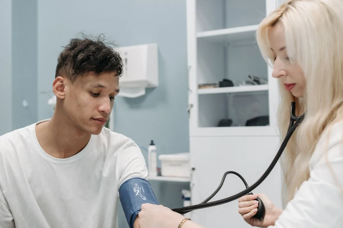 A doctor checking a patient's blood pressure during a clinic visit