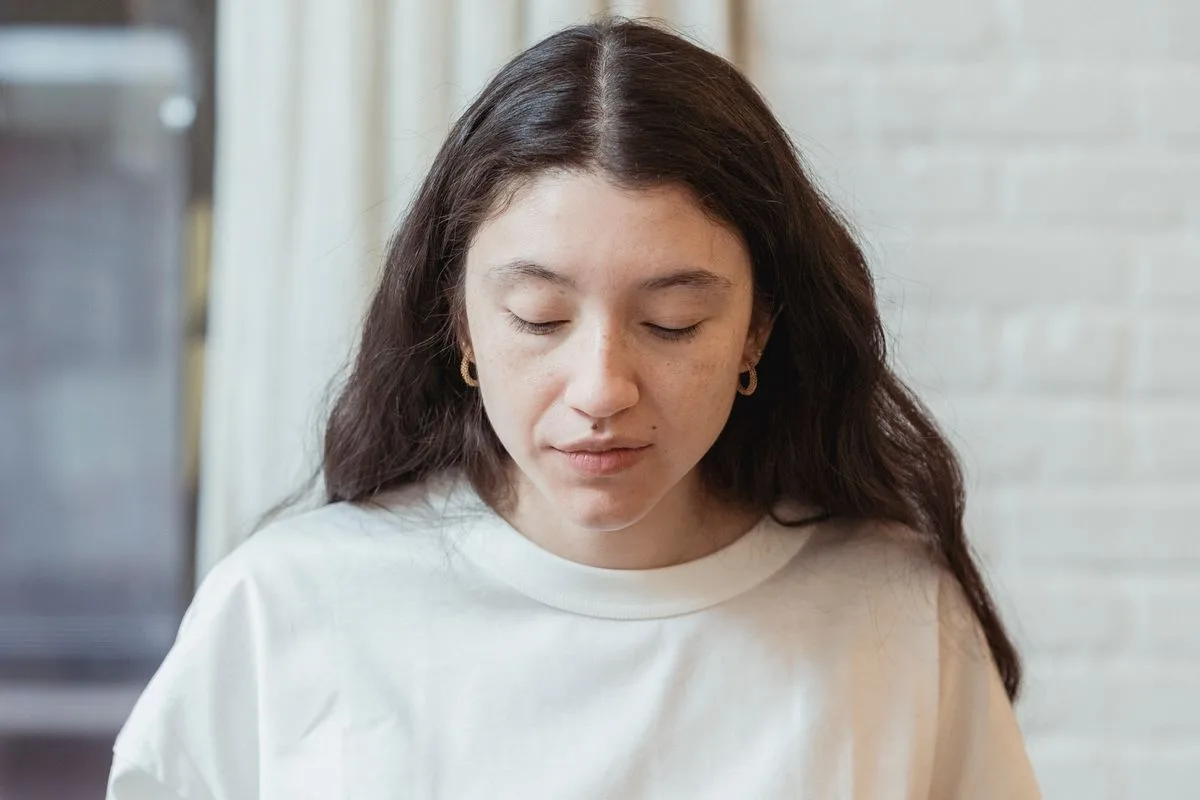 A woman eating a meal slowly and attentively, with a calm, present expression