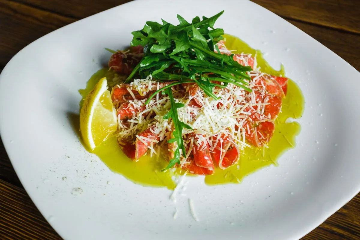 A plate of salmon with arugula, parmesan and olive oil, a classic anti-inflammatory combination