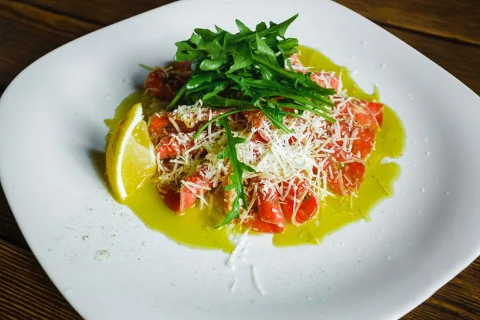 A plate of salmon with arugula, parmesan and olive oil, a classic anti-inflammatory combination