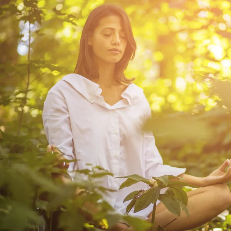 a woman meditating in the woods